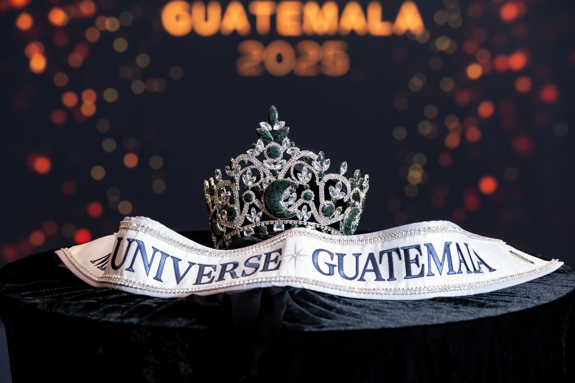 Miss Universe Guatemala — corona dorada sobre fondo azul navy